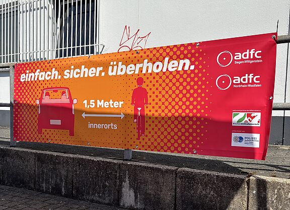Ein Banner weist auf den gesetzlich vorgeschriebenen Überholabstand von 1,5 Metern innerorts hin.